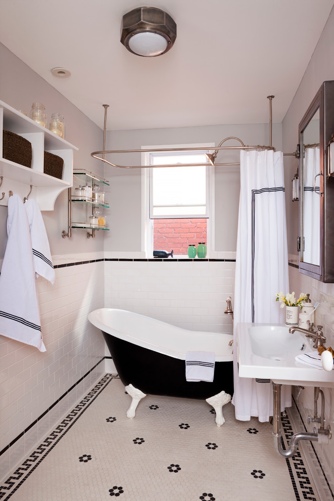 Exempel på ett mellanstort eklektiskt badrum, med ett väggmonterat handfat, vita skåp, ett badkar med tassar, en dusch/badkar-kombination, en toalettstol med hel cisternkåpa, porslinskakel, grå väggar, klinkergolv i porslin, svart och vit kakel och dusch med duschdraperi