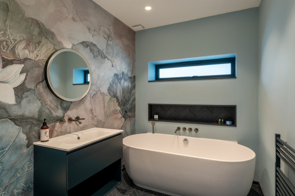 Идея дизайна: главная ванная комната среднего размера в современном стиле с плоскими фасадами, серыми фасадами, отдельно стоящей ванной, полом из керамической плитки, тумбой под одну раковину, напольной тумбой и обоями на стенах