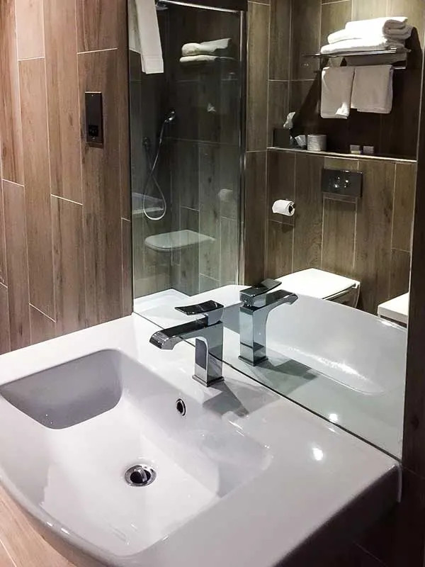 Medium sized scandinavian family bathroom in London with a one-piece toilet, a built-in bath, a walk-in shower, brown tiles, wood-effect tiles, porcelain flooring, a console sink, brown floors, an open shower, a single sink and a floating vanity unit.