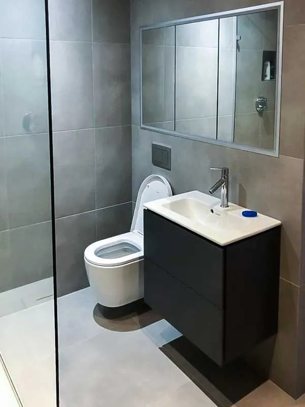 Idéer för små funkis vitt en-suite badrum, med släta luckor, svarta skåp, en öppen dusch, en toalettstol med hel cisternkåpa, grå kakel, keramikplattor, grå väggar, klinkergolv i porslin, grått golv och med dusch som är öppen