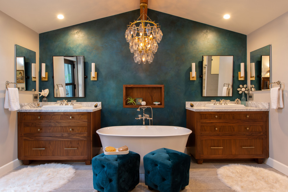 Idée de décoration pour une salle de bain principale marine en bois brun avec un placard à porte shaker, une baignoire indépendante, un mur beige, une vasque, un sol beige, meuble double vasque et meuble-lavabo encastré.