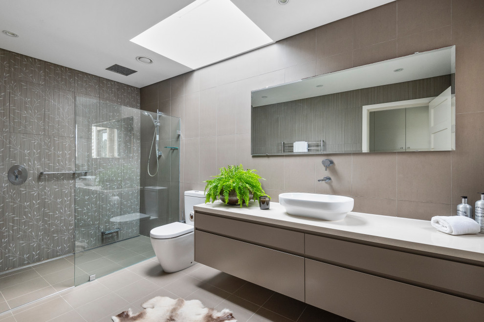 Ispirazione per una stanza da bagno design con ante lisce, ante grigie, doccia alcova, piastrelle grigie, lavabo a bacinella, pavimento grigio, doccia aperta e top bianco