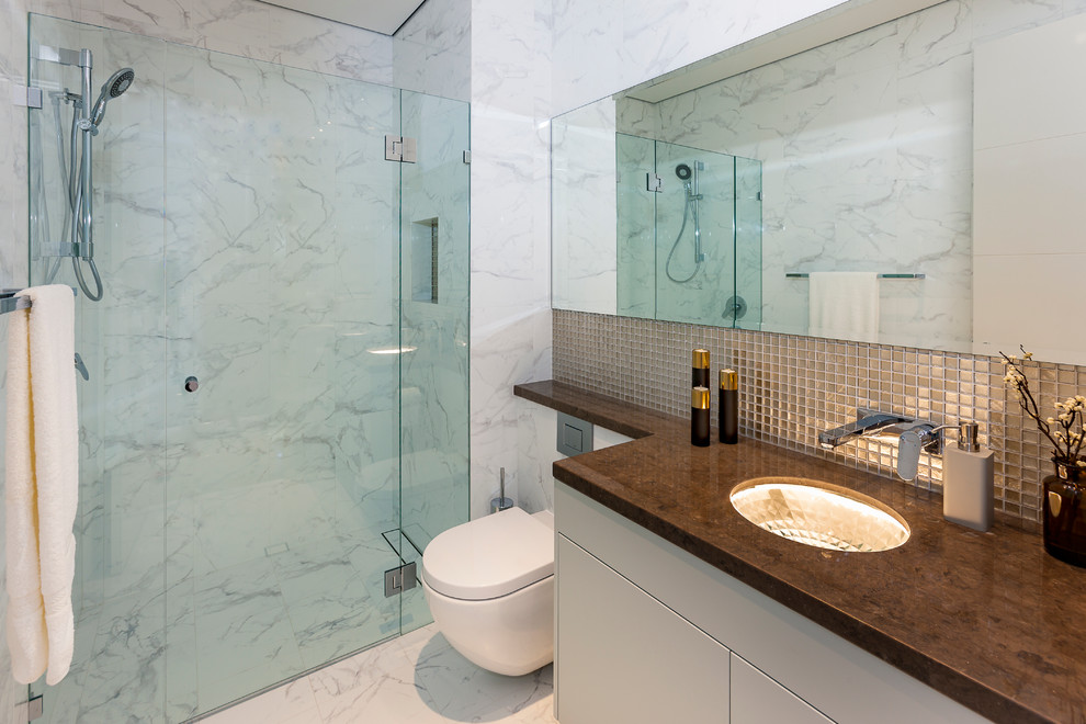 Exempel på ett modernt badrum med dusch, med släta luckor, vita skåp, en dusch i en alkov, ett undermonterad handfat och dusch med gångjärnsdörr