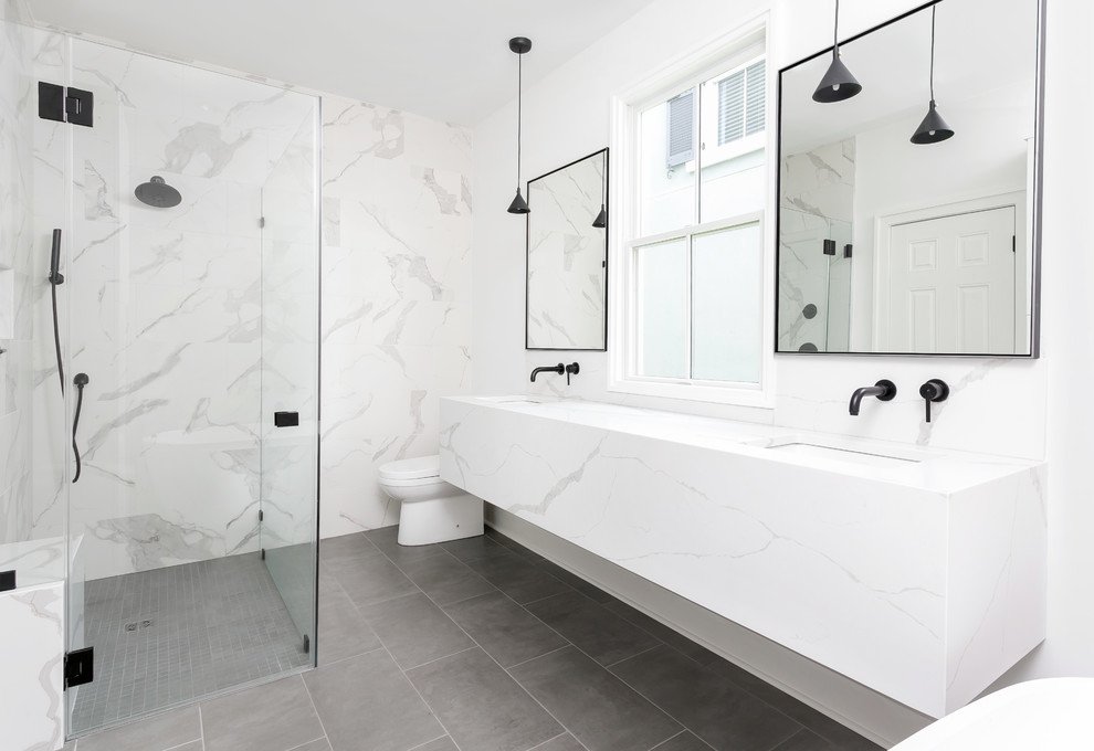 チャールストンにあるコンテンポラリースタイルのおしゃれな浴室 (バリアフリー、白いタイル、白い壁、アンダーカウンター洗面器、グレーの床、開き戸のシャワー、白い洗面カウンター) の写真