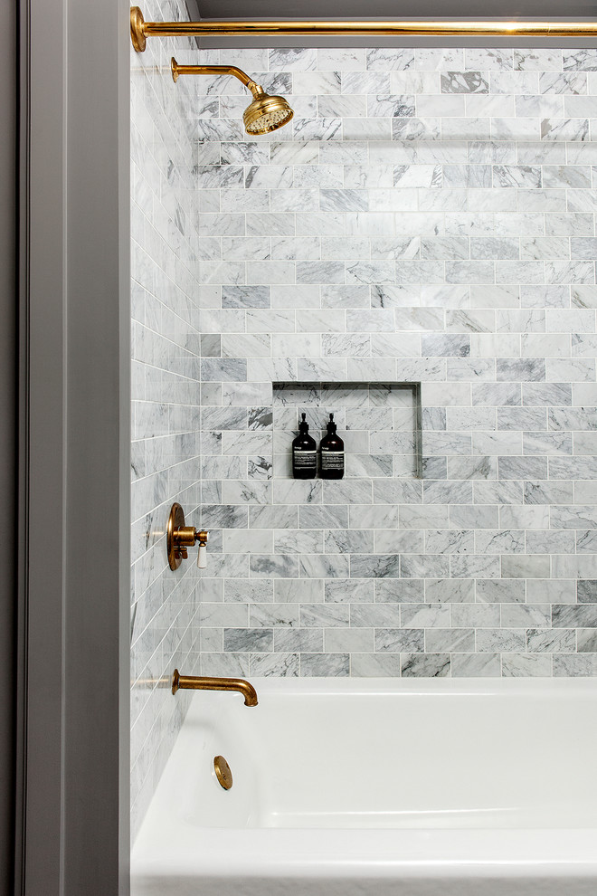 Inredning av ett maritimt mellanstort badrum, med öppna hyllor, ett badkar i en alkov, en dusch/badkar-kombination, vit kakel, marmorkakel, marmorbänkskiva och dusch med duschdraperi