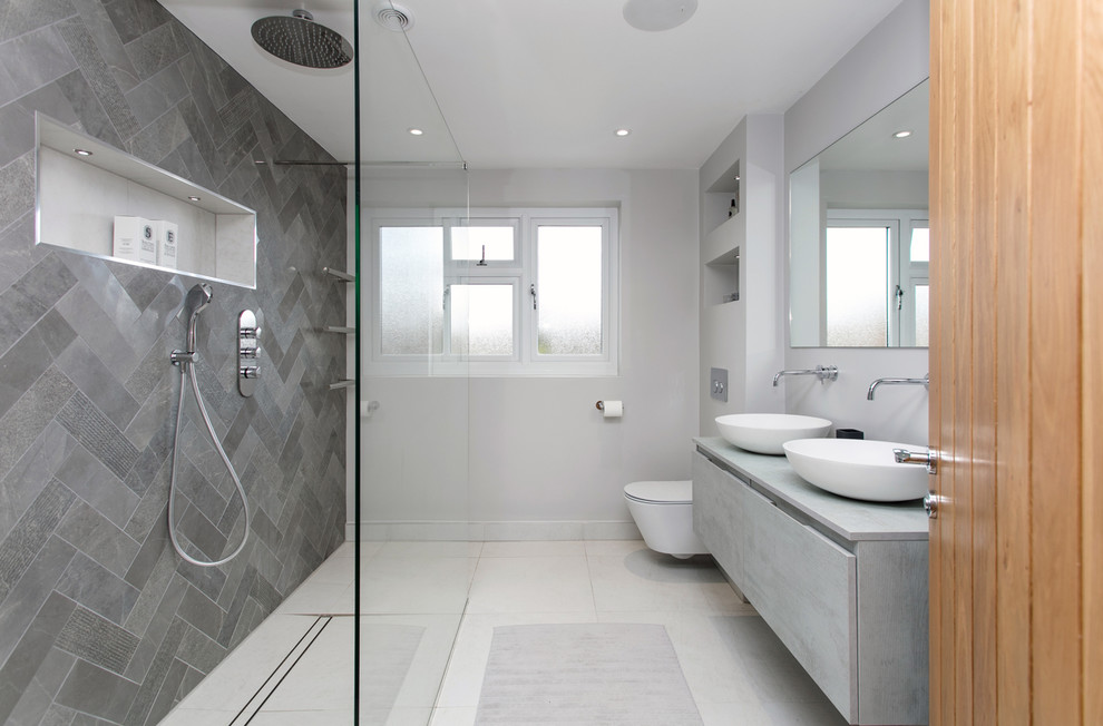 Exempel på ett mellanstort modernt grå grått en-suite badrum, med släta luckor, grå skåp, en öppen dusch, en vägghängd toalettstol, grå kakel, porslinskakel, grå väggar, klinkergolv i porslin, ett väggmonterat handfat, bänkskiva i kvartsit, grått golv och med dusch som är öppen