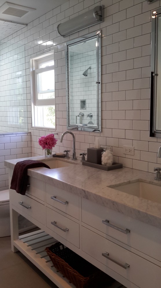Inspiration for a mid-sized transitional 3/4 white tile and subway tile concrete floor alcove shower remodel in Los Angeles with flat-panel cabinets, white cabinets, a two-piece toilet, white walls, an undermount sink and marble countertops