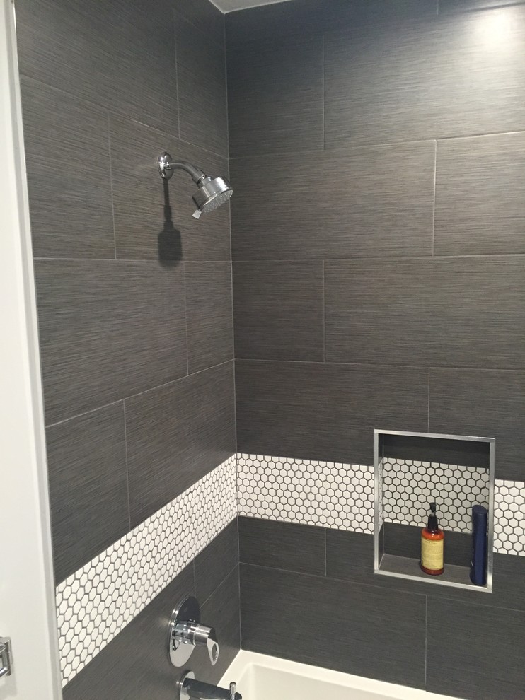 Cette image montre une salle de bain design de taille moyenne avec un placard à porte plane, des portes de placard blanches, une baignoire en alcôve, un combiné douche/baignoire, WC séparés, un carrelage gris, un mur gris et un lavabo intégré.