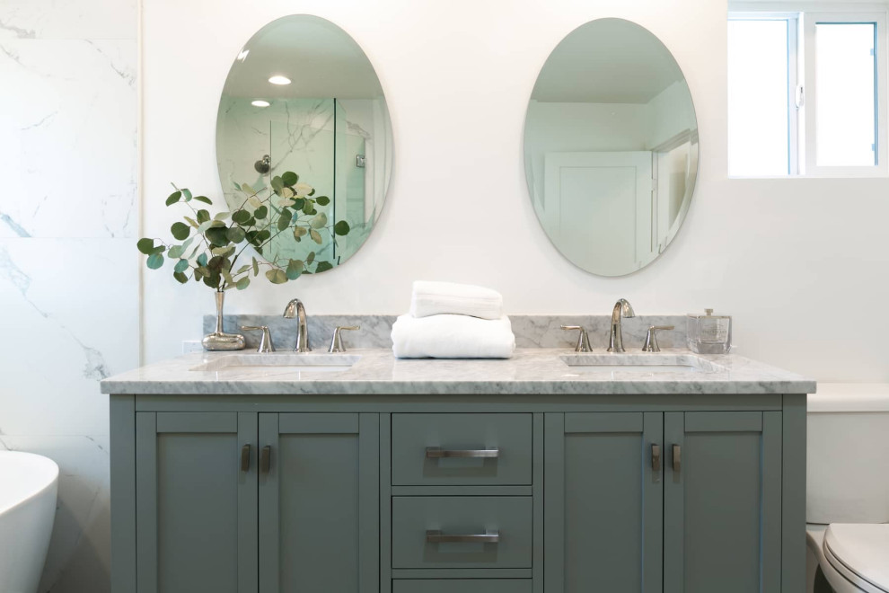Источник вдохновения для домашнего уюта: большая главная ванная комната в современном стиле с фасадами с утопленной филенкой, серыми фасадами, отдельно стоящей ванной, угловым душем, унитазом-моноблоком, белой плиткой, мраморной плиткой, белыми стенами, полом из керамической плитки, врезной раковиной, мраморной столешницей, серым полом, душем с распашными дверями, серой столешницей, тумбой под две раковины и напольной тумбой