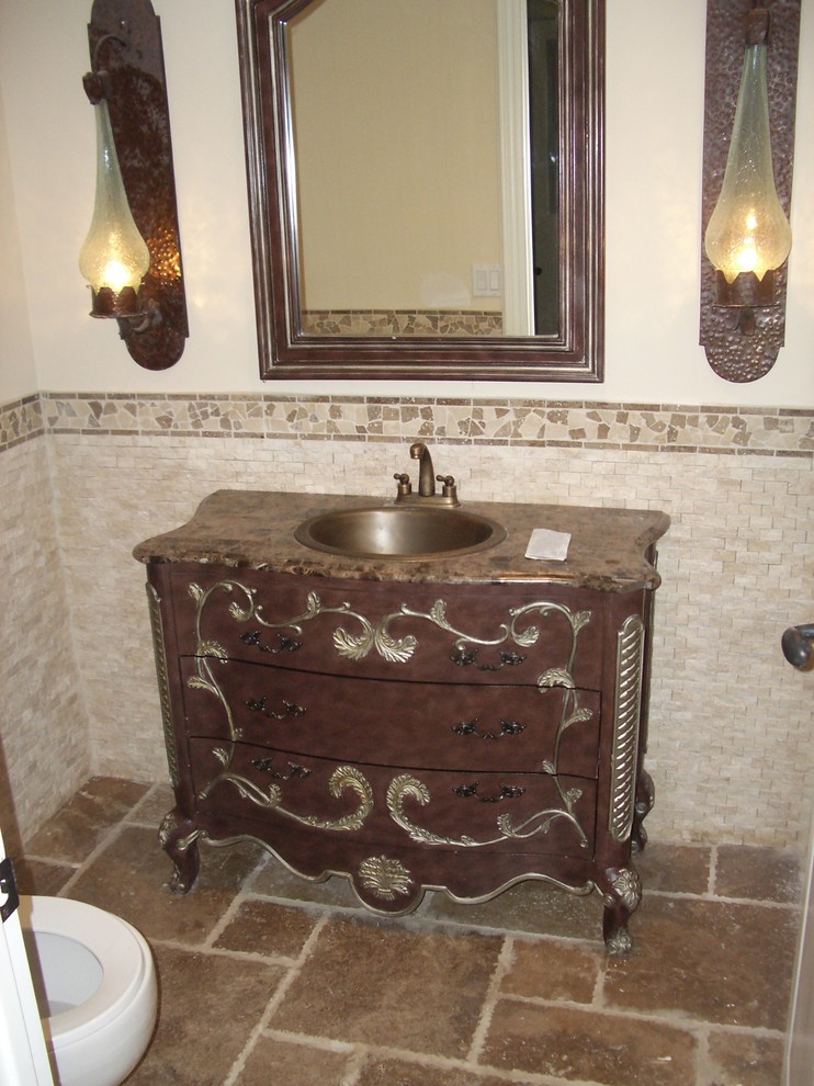 Cette image montre une petite salle de bain méditerranéenne en bois foncé avec un placard avec porte à panneau surélevé, une baignoire posée, WC à poser, un carrelage multicolore, un carrelage de pierre, un mur beige, un sol en travertin, un lavabo posé, un plan de toilette en béton, un sol multicolore, une cabine de douche à porte battante et un plan de toilette beige.