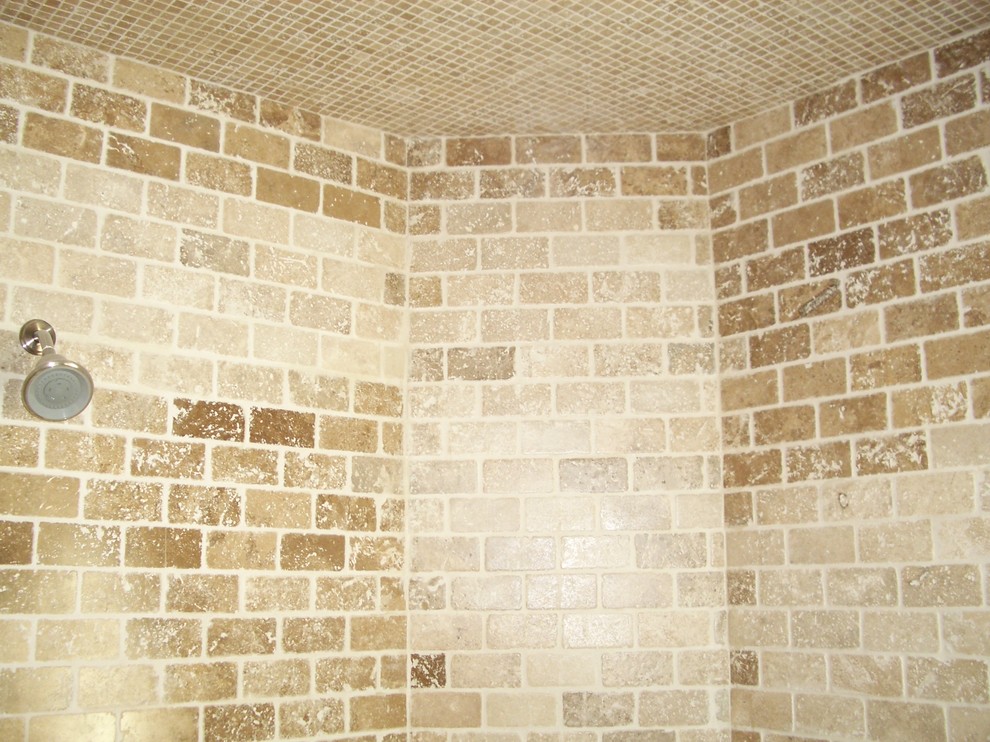 This is an example of a medium sized mediterranean shower room bathroom in Los Angeles with freestanding cabinets, dark wood cabinets, an alcove shower, a one-piece toilet, multi-coloured tiles, stone tiles, beige walls, travertine flooring, a built-in sink, concrete worktops, multi-coloured floors, a hinged door, beige worktops and a built-in bath.