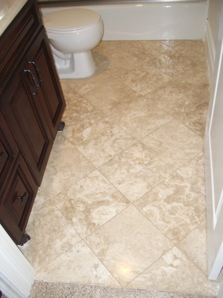 Example of a small tuscan 3/4 multicolored tile and stone tile travertine floor and multicolored floor bathroom design in Los Angeles with raised-panel cabinets, dark wood cabinets, a one-piece toilet, beige walls, a drop-in sink, concrete countertops, a hinged shower door and beige countertops