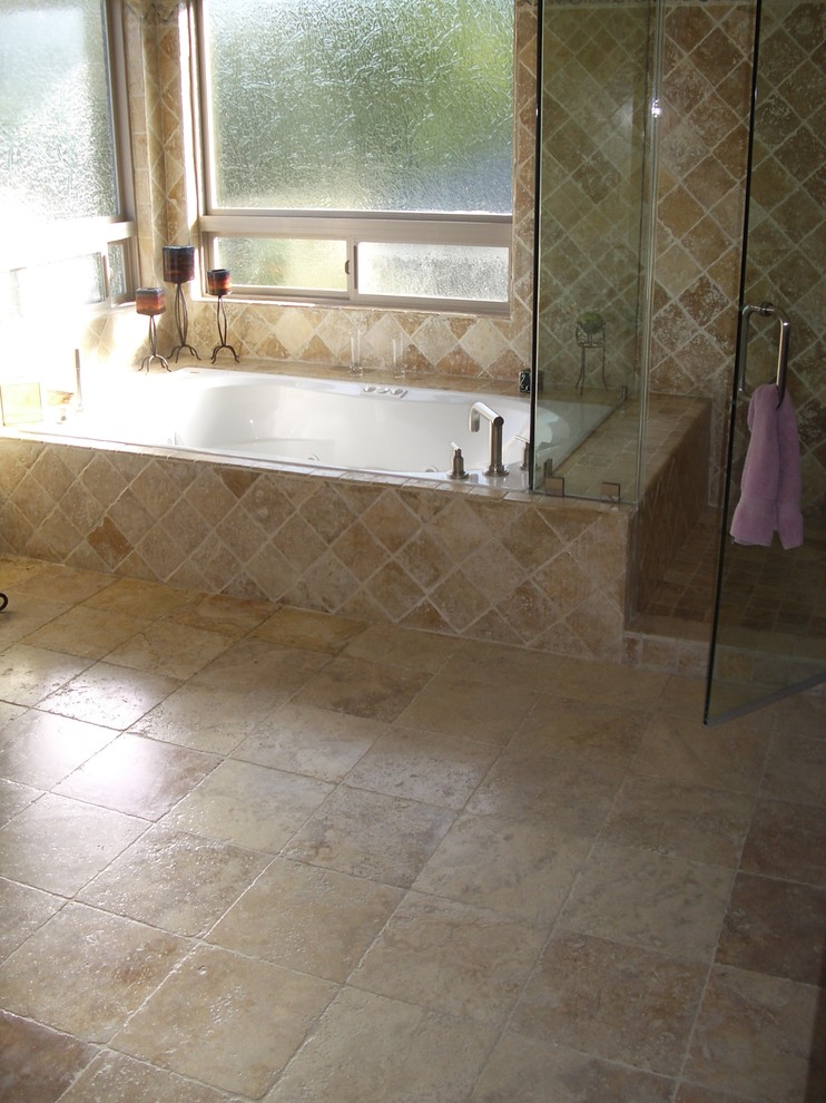 Inspiration för ett mellanstort medelhavsstil badrum med dusch, med ett fristående badkar, en dusch i en alkov, dusch med gångjärnsdörr, beige väggar, travertin golv och flerfärgat golv