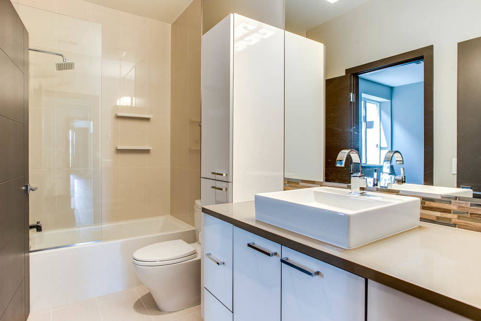 Design ideas for a small contemporary family bathroom in Denver with a vessel sink, flat-panel cabinets, white cabinets, quartz worktops, an alcove bath, an alcove shower, a one-piece toilet, beige tiles, porcelain tiles, grey walls and porcelain flooring.