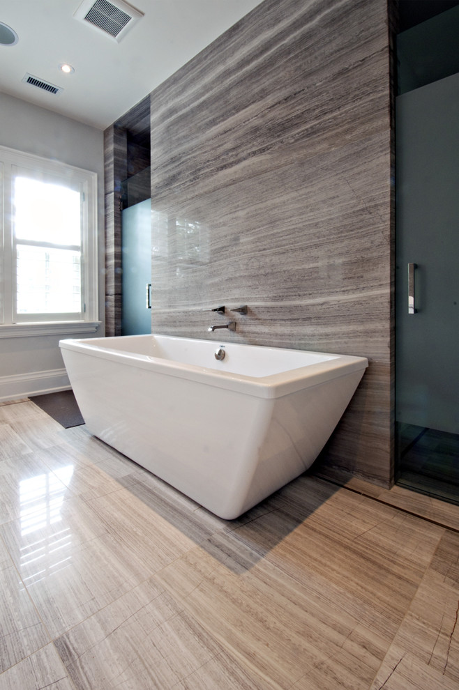 This is an example of a contemporary bathroom in Toronto with a freestanding bath, grey tiles and stone slabs.