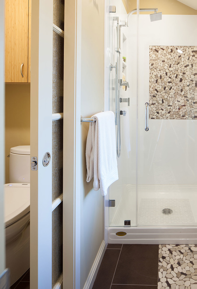 Photo of a large beach style ensuite bathroom in San Francisco with a vessel sink, flat-panel cabinets, medium wood cabinets, solid surface worktops, a freestanding bath, an alcove shower, a two-piece toilet, brown tiles, porcelain tiles, yellow walls and porcelain flooring.