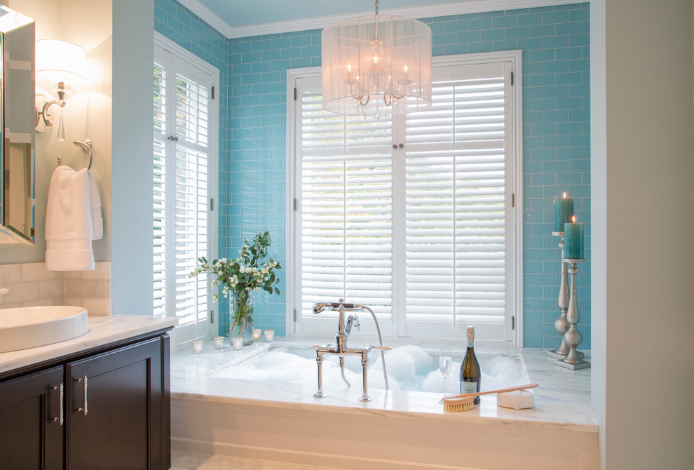 Exemple d'une salle de bain principale chic en bois foncé de taille moyenne avec une vasque, un placard avec porte à panneau encastré, un plan de toilette en marbre, une baignoire encastrée, une douche à l'italienne, WC séparés, un carrelage bleu, un carrelage en pâte de verre, un mur bleu et un sol en marbre.