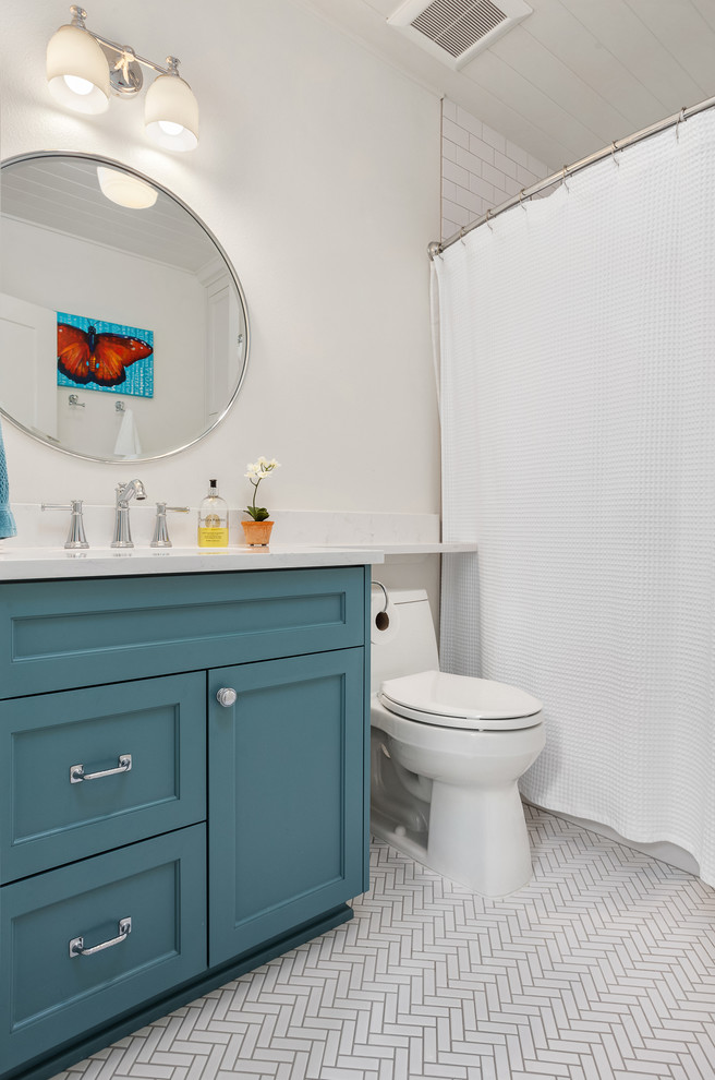 Пример оригинального дизайна: ванная комната в современном стиле с фасадами с утопленной филенкой, бирюзовыми фасадами, ванной в нише, душем над ванной, унитазом-моноблоком, белой плиткой, плиткой кабанчик, белыми стенами, полом из керамической плитки, белым полом, шторкой для ванной и белой столешницей