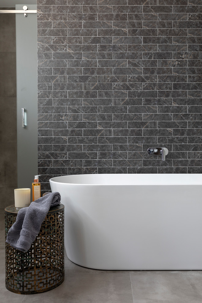 Immagine di una grande stanza da bagno padronale design con vasca freestanding, piastrelle in ceramica, pavimento con piastrelle in ceramica, pavimento grigio e piastrelle nere