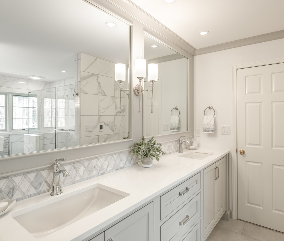 Bathroom - large transitional master gray tile and ceramic tile porcelain tile and white floor bathroom idea in Other with recessed-panel cabinets, gray cabinets, gray walls, an undermount sink, quartz countertops, a hinged shower door and white countertops