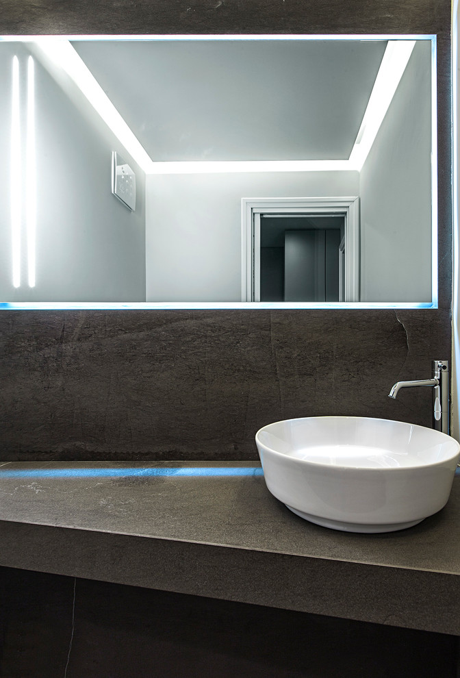 Modelo de cuarto de baño contemporáneo con losas de piedra y suelo de madera en tonos medios