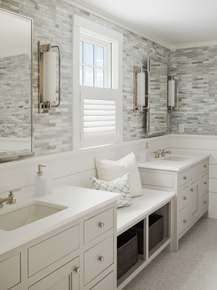 Пример оригинального дизайна: ванная комната в стиле неоклассика (современная классика) с врезной раковиной, серыми фасадами, серой плиткой, белыми стенами, плоскими фасадами и зеркалом с подсветкой