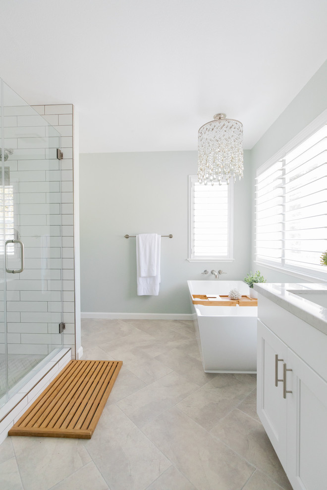 Example of a mid-sized transitional master gray tile and porcelain tile porcelain tile and gray floor bathroom design in Sacramento with shaker cabinets, white cabinets, a two-piece toilet, green walls, an undermount sink, quartz countertops, a hinged shower door and white countertops