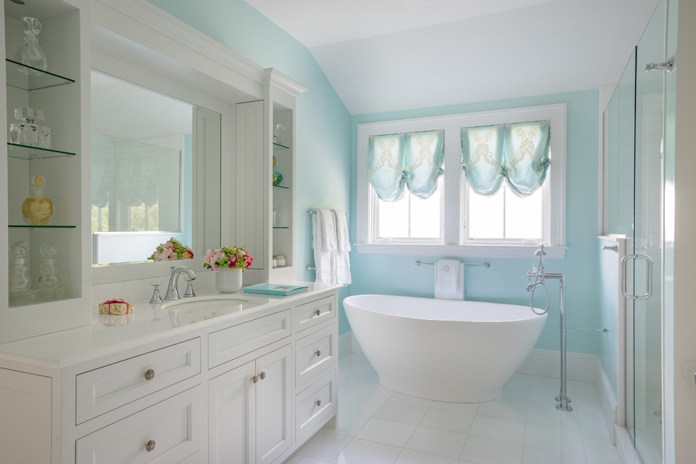 Foto på ett vintage vit en-suite badrum, med luckor med infälld panel, vita skåp, ett fristående badkar, blå väggar, ett undermonterad handfat, bänkskiva i kvarts, vitt golv, dusch med gångjärnsdörr och en dusch i en alkov