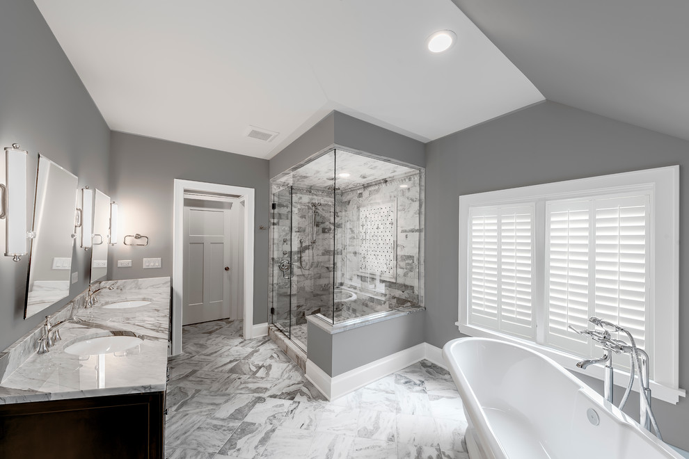Inredning av ett klassiskt stort en-suite badrum, med skåp i mörkt trä, ett fristående badkar, en dusch i en alkov, grå kakel, flerfärgad kakel, vit kakel, marmorkakel, grå väggar, marmorgolv, ett undermonterad handfat, marmorbänkskiva, grått golv och dusch med gångjärnsdörr