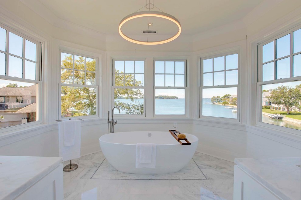 Ejemplo de cuarto de baño principal marinero con bañera exenta, paredes blancas y suelo blanco