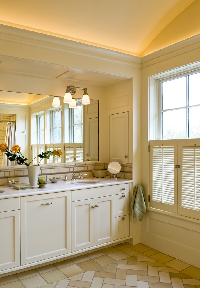 Esempio di una stanza da bagno vittoriana con lavabo sottopiano, ante in stile shaker, ante beige e piastrelle beige