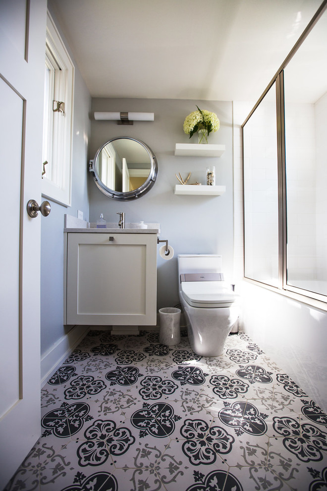 Example of a mid-sized beach style 3/4 multicolored floor and porcelain tile bathroom design in Milwaukee with recessed-panel cabinets, white cabinets, a one-piece toilet, gray walls, an undermount sink and gray countertops