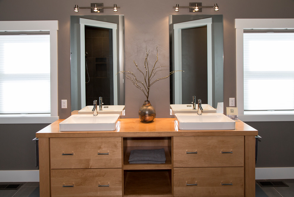 Inredning av ett amerikanskt mellanstort en-suite badrum, med möbel-liknande, skåp i ljust trä, grå väggar, klinkergolv i porslin, ett fristående handfat, träbänkskiva och svart golv