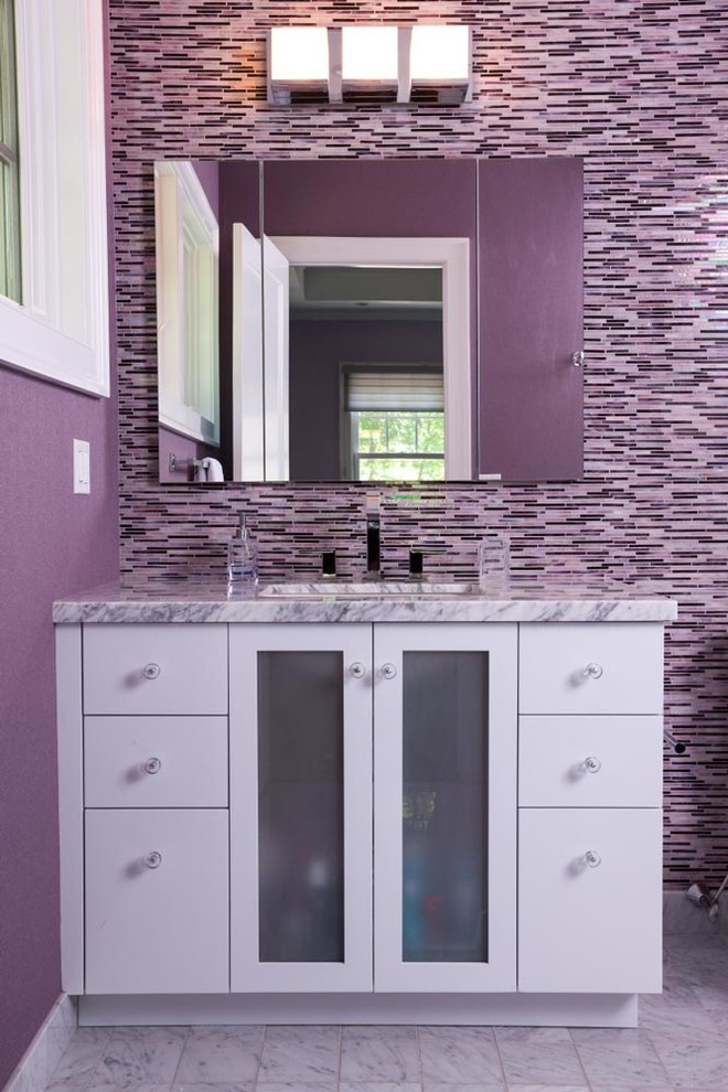 ニューヨークにある小さなコンテンポラリースタイルのおしゃれなバスルーム (浴槽なし) (アンダーカウンター洗面器、ガラス扉のキャビネット、白いキャビネット、大理石の洗面台、マルチカラーのタイル、モザイクタイル、紫の壁、大理石の床、一体型トイレ	) の写真