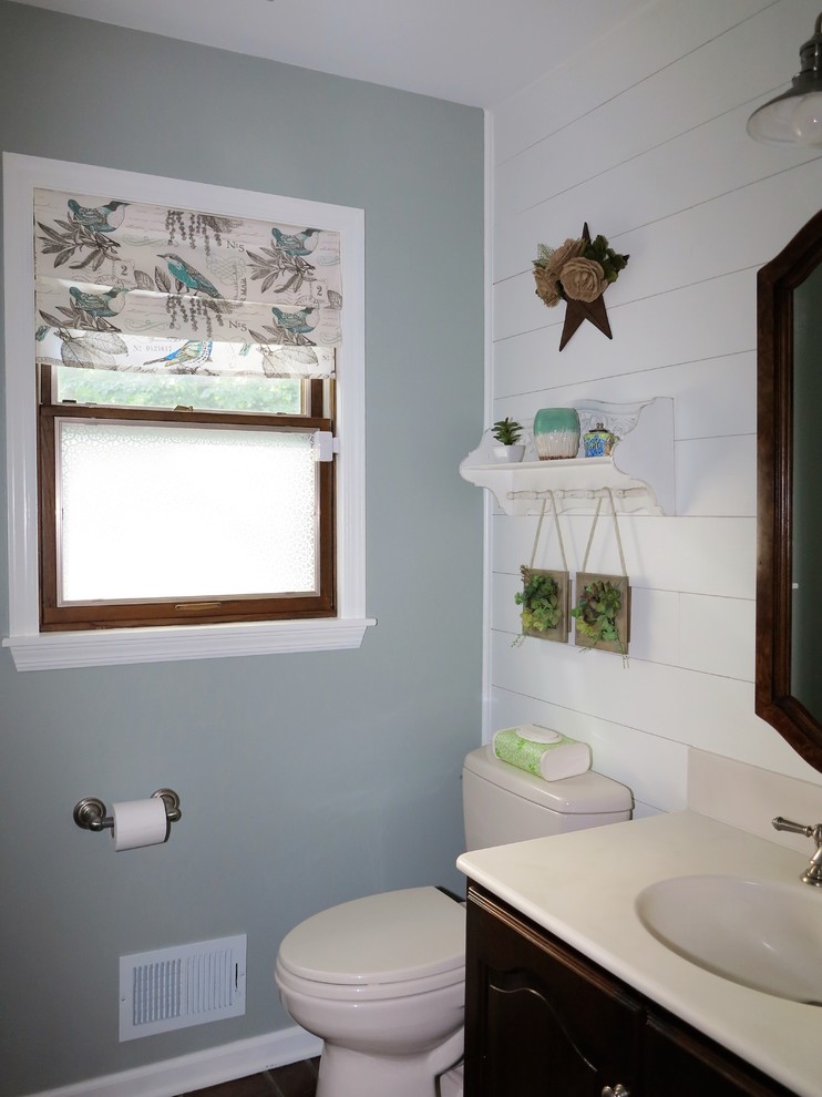 Diseño de cuarto de baño de estilo de casa de campo pequeño con puertas de armario de madera en tonos medios, sanitario de dos piezas, encimera de acrílico, suelo marrón y encimeras blancas