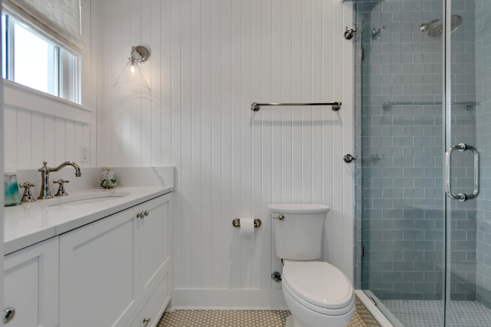 Foto på ett maritimt grå badrum, med skåp i shakerstil, grå skåp, en öppen dusch, en toalettstol med separat cisternkåpa, blå kakel, porslinskakel, vita väggar, klinkergolv i porslin, ett undermonterad handfat, marmorbänkskiva och blått golv