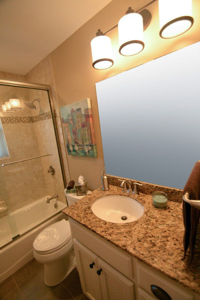 Пример оригинального дизайна: главная ванная комната среднего размера в классическом стиле с фасадами с утопленной филенкой, белыми фасадами, ванной в нише, душем над ванной, раздельным унитазом, коричневой плиткой, керамической плиткой, бежевыми стенами, полом из керамогранита, врезной раковиной и столешницей из гранита