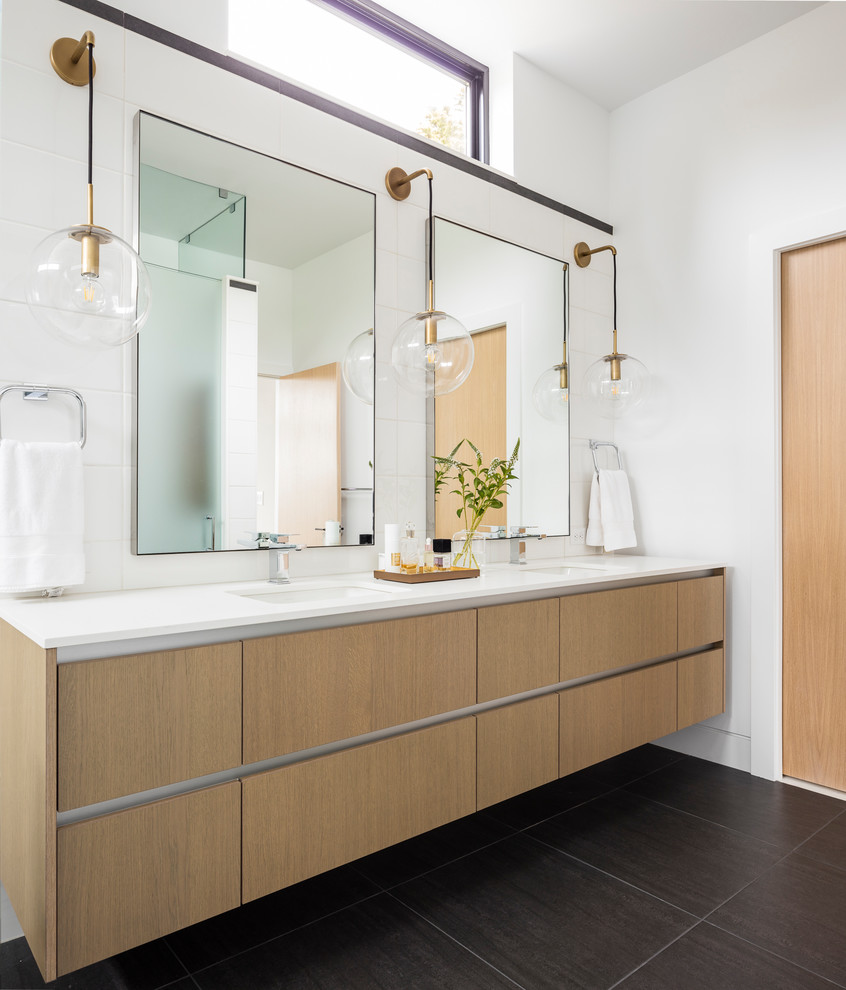 Large contemporary shower room bathroom in Seattle with flat-panel cabinets, medium wood cabinets, white tiles, white walls, a submerged sink, black floors, white worktops, an alcove shower, porcelain flooring, engineered stone worktops and a hinged door.