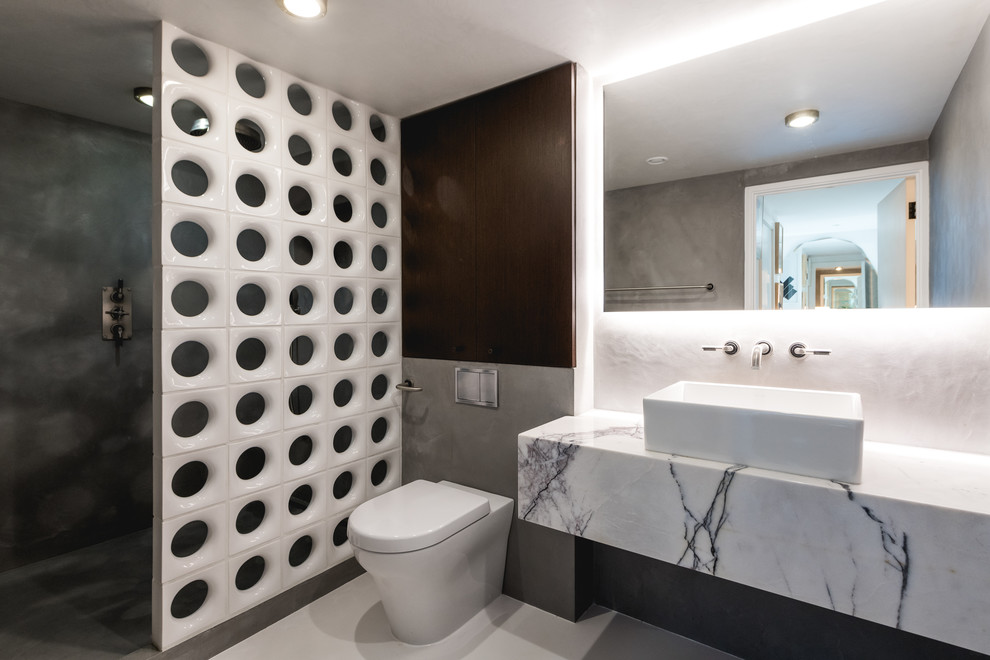 Photo of a medium sized industrial bathroom in London with a walk-in shower, a one-piece toilet, a vessel sink, grey floors and an open shower.