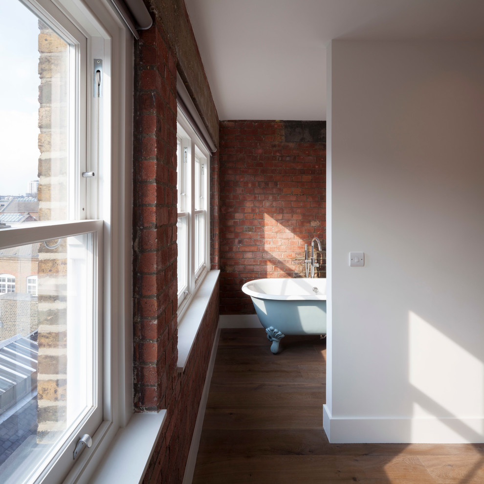 Mittelgroßes Modernes Badezimmer En Suite mit Löwenfuß-Badewanne, Duschbadewanne und braunem Holzboden in London