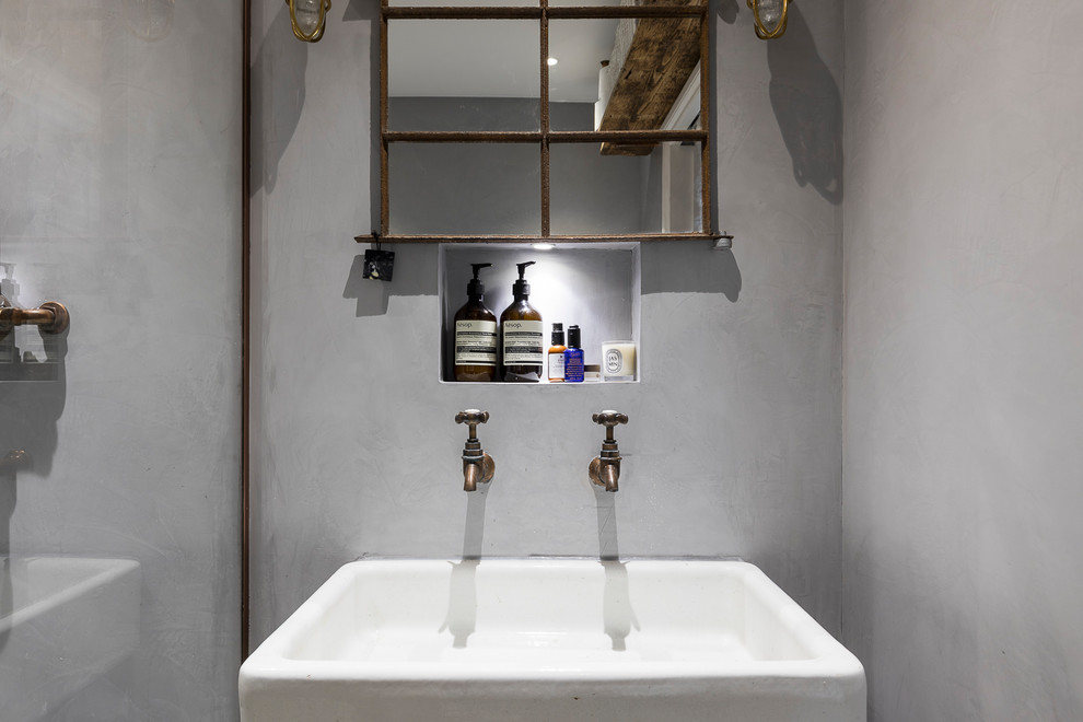 Immagine di una stanza da bagno per bambini industriale di medie dimensioni con doccia aperta, piastrelle di vetro, pareti grigie, pavimento in cementine e lavabo a bacinella