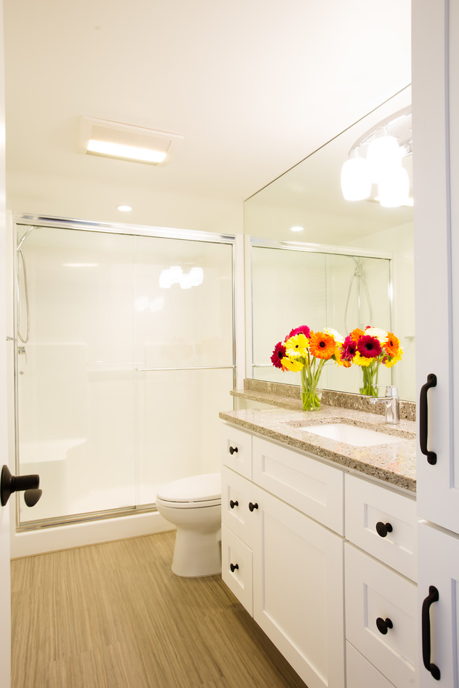 Ejemplo de cuarto de baño clásico renovado de tamaño medio con armarios estilo shaker, puertas de armario blancas, sanitario de una pieza, paredes blancas, suelo de linóleo y encimera de cuarzo compacto