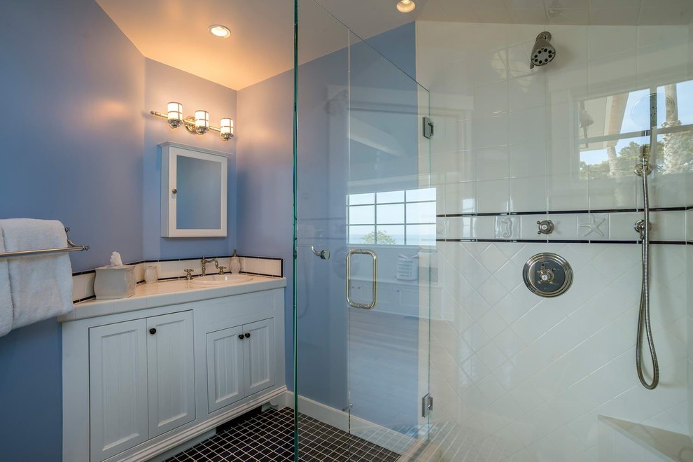 Стильный дизайн: маленькая ванная комната в морском стиле с фасадами с декоративным кантом, белыми фасадами, угловым душем, белой плиткой, керамической плиткой, синими стенами, полом из керамической плитки, душевой кабиной и накладной раковиной для на участке и в саду - последний тренд