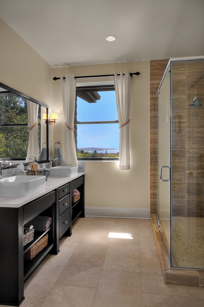 Cette photo montre une salle de bain chic avec une vasque, des portes de placard noires et un plan de toilette blanc.