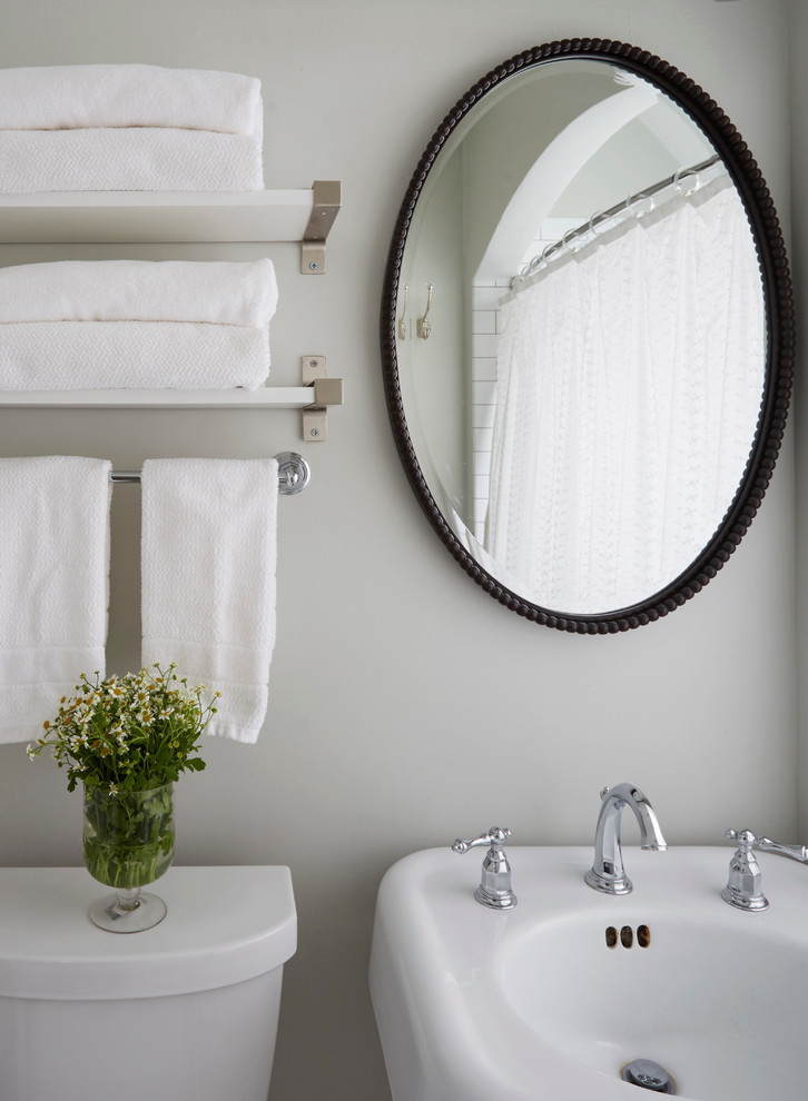 Klassisk inredning av ett litet badrum, med skåp i shakerstil, vita skåp, ett badkar i en alkov, en dusch i en alkov, en toalettstol med separat cisternkåpa, vit kakel, keramikplattor, grå väggar, klinkergolv i keramik och ett piedestal handfat