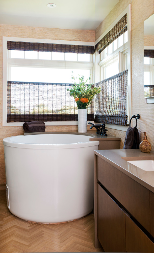 Idee per una stanza da bagno minimal con ante lisce, ante in legno bruno, vasca giapponese, pareti beige, parquet chiaro e lavabo sottopiano