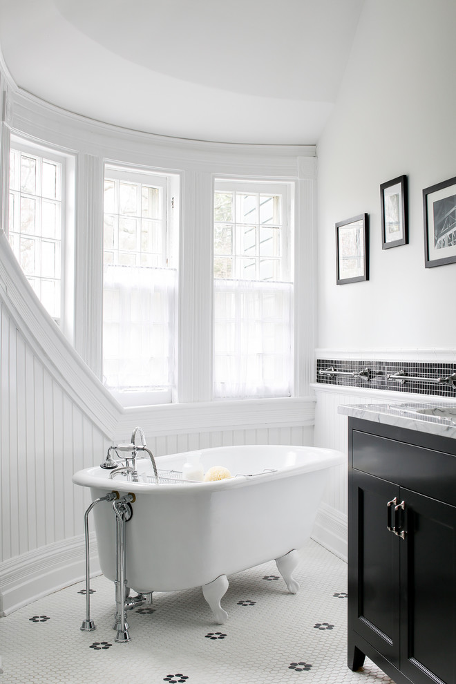 Foto de cuarto de baño clásico con armarios estilo shaker, puertas de armario negras, bañera con patas, baldosas y/o azulejos blancas y negros y paredes blancas