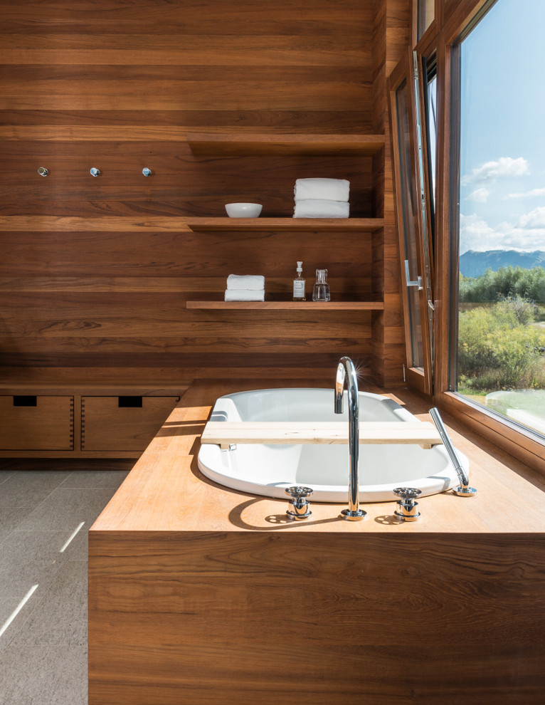 Foto på ett funkis badrum, med släta luckor, skåp i mellenmörkt trä och ett platsbyggt badkar