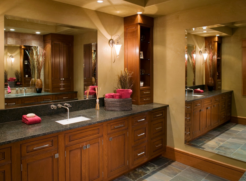 This is an example of a large rustic ensuite bathroom in Other with recessed-panel cabinets, dark wood cabinets, a built-in bath, beige walls, slate flooring, a submerged sink, granite worktops and grey floors.