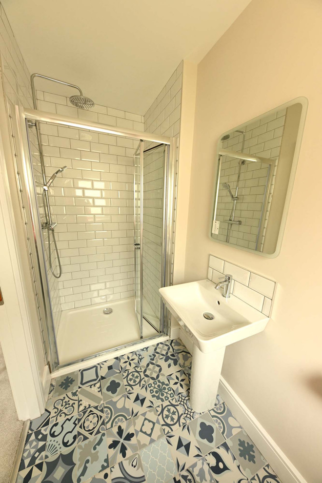 Kleines Stilmix Badezimmer En Suite mit bodengleicher Dusche, weißen Fliesen, weißer Wandfarbe, Porzellan-Bodenfliesen, Waschtischkonsole, blauem Boden, Falttür-Duschabtrennung und Einzelwaschbecken in Cork